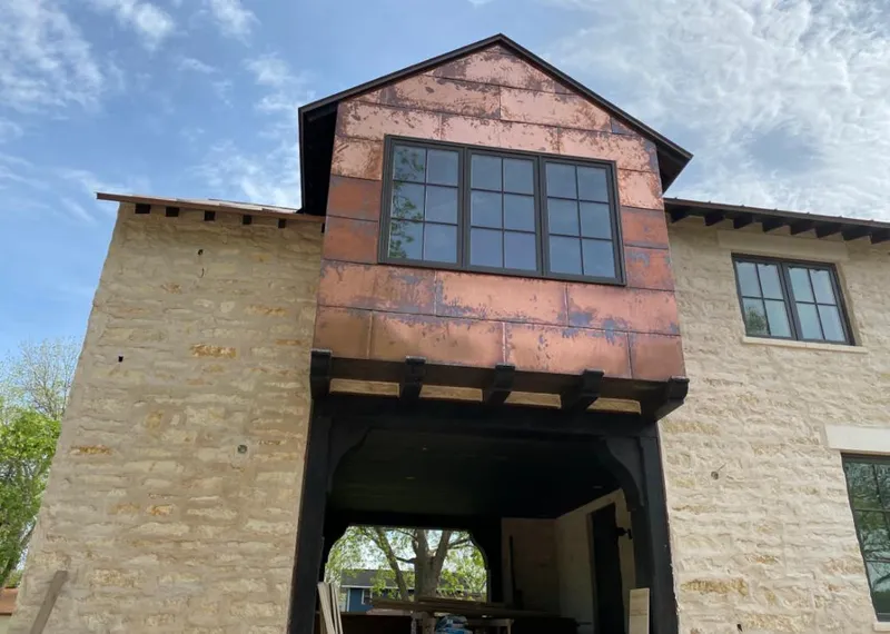Copper metal panel facade on a stone building for Skylight Installation in West Deer